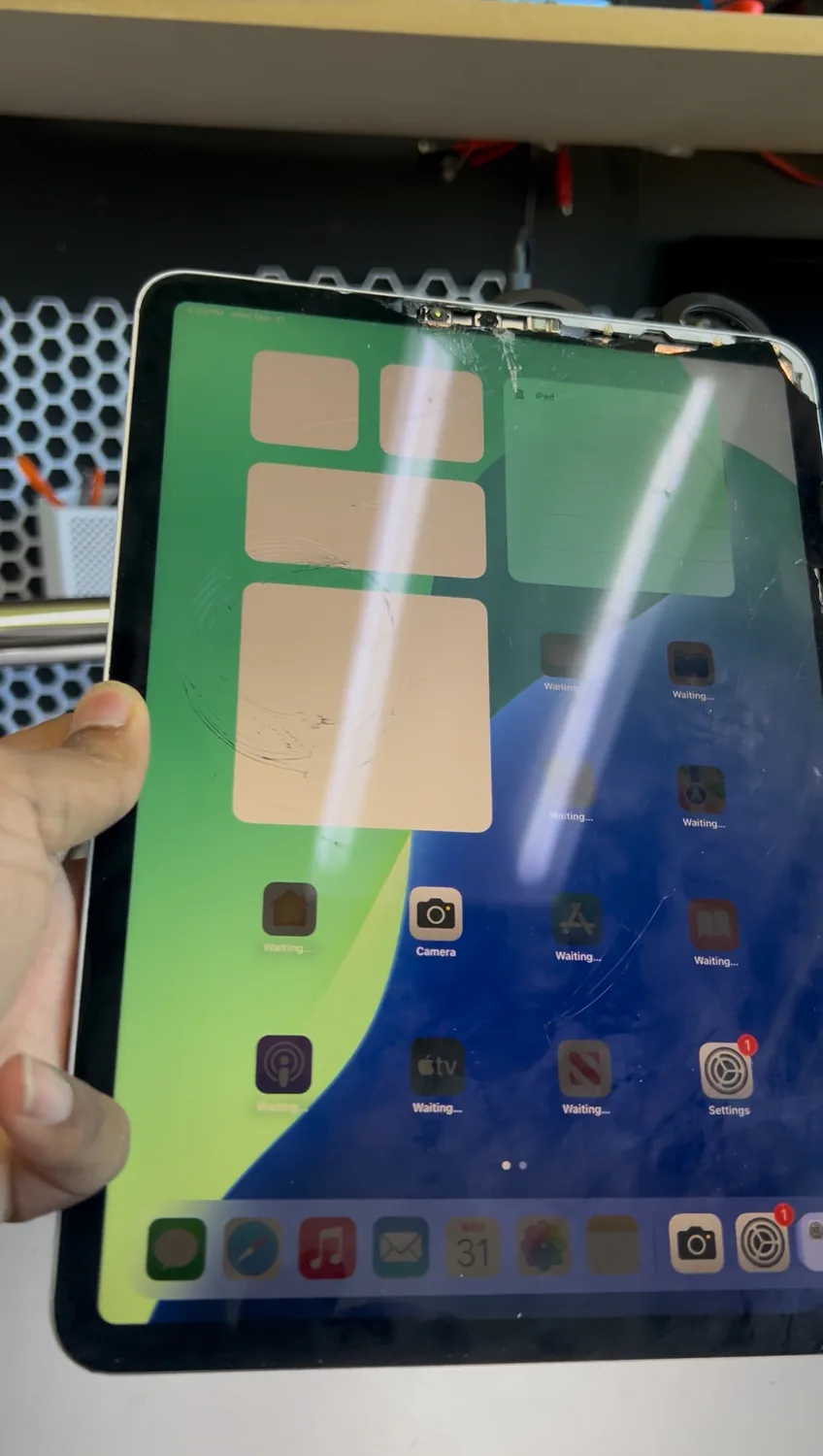 Shattered iPad front glass on the bench before a glass-only replacement