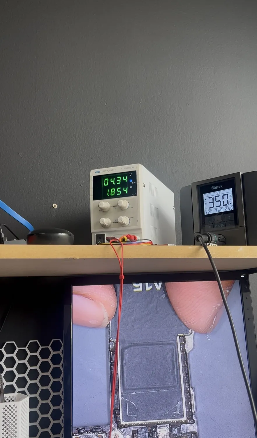 iPhone 13 logic board pulling 1.8 amps on a bench power supply, indicating a dead short