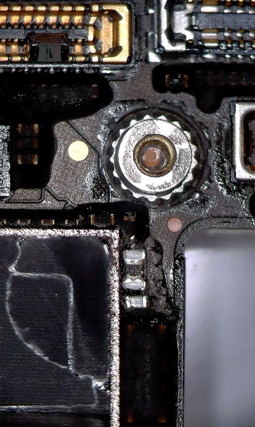 The shorted capacitor on the iPhone 13 NAND power line under a microscope