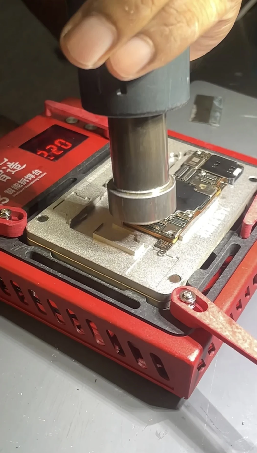 iPhone 14 Pro Max board layers clamped in an alignment fixture and heated to bond them together