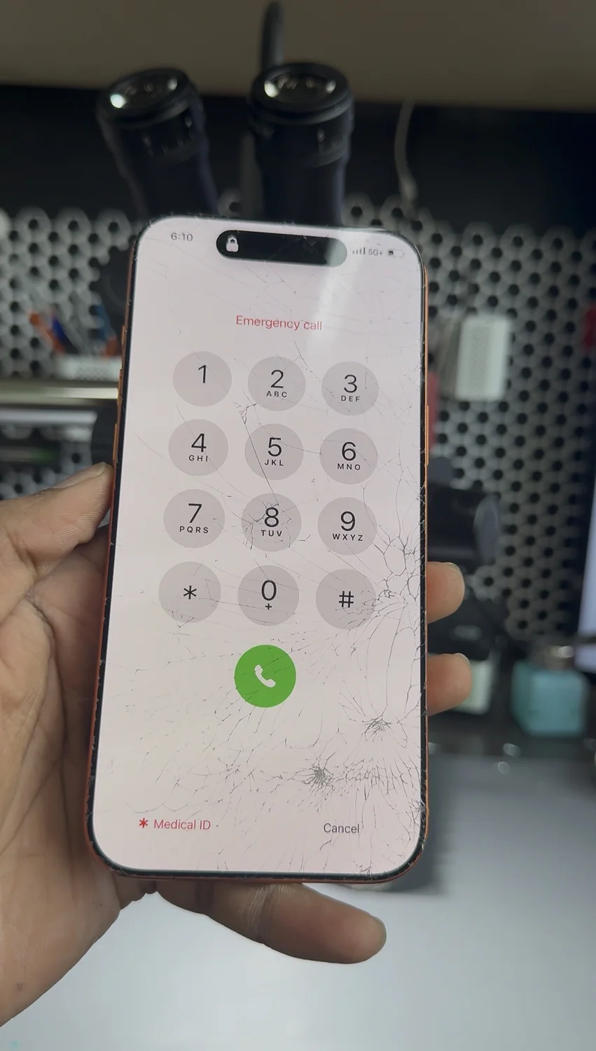 iPhone 17 Pro Max with shattered front glass still showing its lock screen