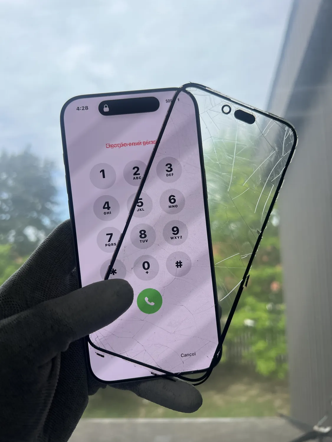 Shattered outer glass lifted off a still-working iPhone display during a glass-only screen replacement in Mississauga
