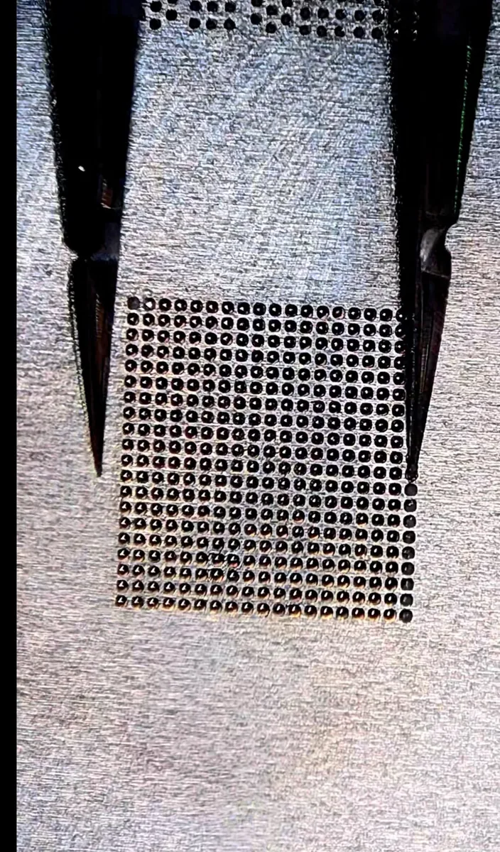 Power management IC after reballing, showing a fresh grid of solder balls