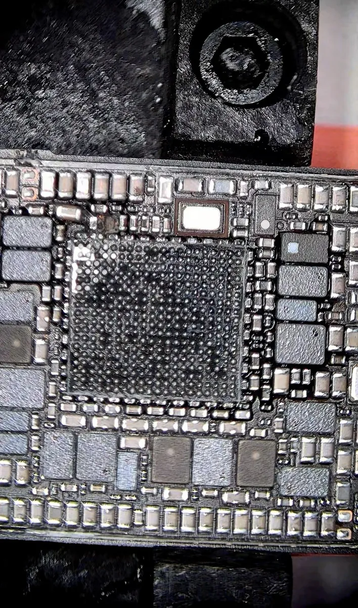 Empty BGA pad array on an iPhone 14 logic board after the power IC was removed