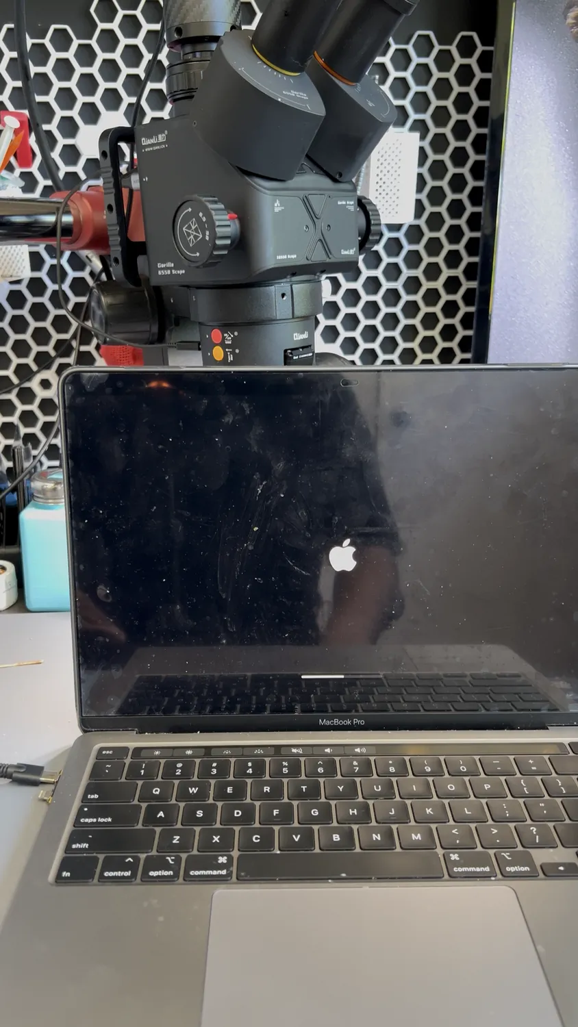 A dead MacBook Pro on the repair bench under a microscope for data recovery in Mississauga