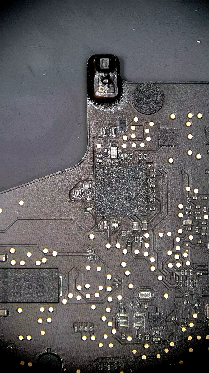 MacBook logic board USB-C power-delivery section repaired under a microscope in Mississauga